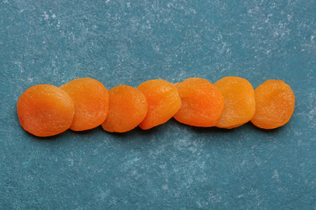 Tasty dried apricots on blue backgroundの写真素材