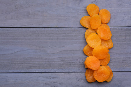 Tasty dried apricots on blue wooden backgroundの写真素材