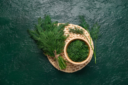 Bowl with fresh dill on green backgroundの写真素材