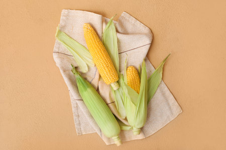 Fresh corn cobs on brown background