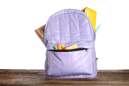 Lilac school backpack with notebooks, pencil case and markers on wooden table near white backgroundの写真素材