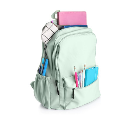 Green school backpack with notebooks, pencil case and pens on white backgroundの写真素材