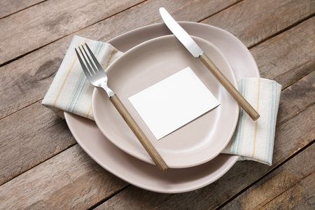 Stylish modern table setting with card on brown wooden backgroundの写真素材