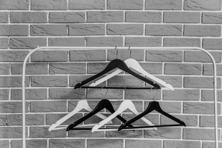 Rack with wooden clothes hangers on gray brick wall backgroundの写真素材