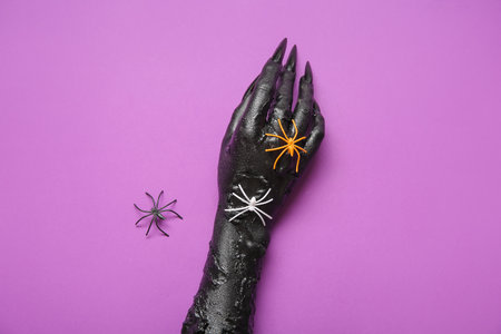 Black hand of witch and spiders on purple background. halloween celebrationの写真素材