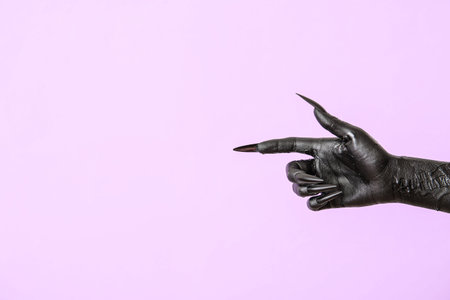 Black hand of witch pointing at something on purple background. halloween celebrationの写真素材