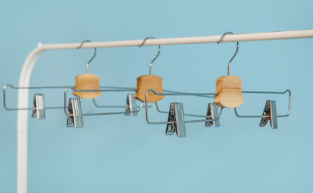 Rack with metal clothes hangers on blue backgroundの写真素材