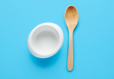 Wooden spoon and bowl on color backgroundの写真素材