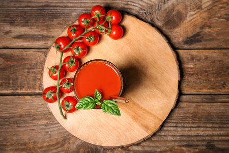 Glass of tasty tomato juice on wooden backgroundの写真素材