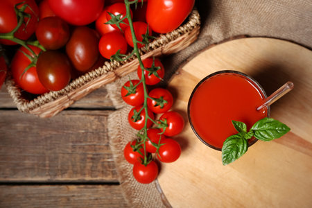 Glass of tasty tomato juice on wooden backgroundの写真素材