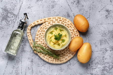 Bowl of tasty mashed potatoes with parsley and rosemary on blue backgroundの写真素材