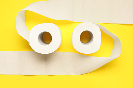Rolls of toilet paper on yellow backgroundの写真素材