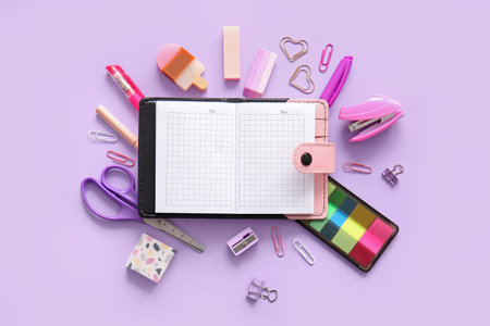 Composition with blank notebook and different school stationery on purple background
