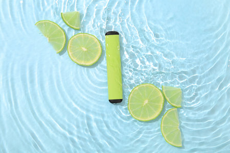 Electronic cigarette with lime in water on blue backgroundの写真素材