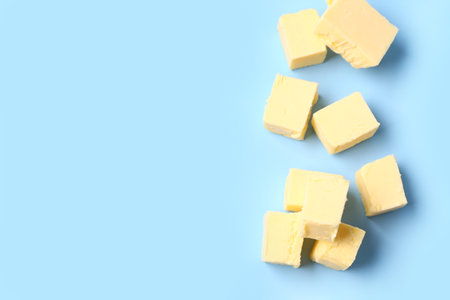 Pieces of fresh butter on blue backgroundの写真素材