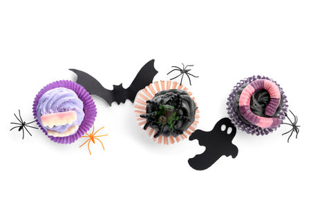 Composition with delicious Halloween cupcakes and decor on white backgroundの写真素材