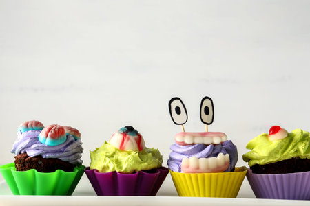 Plate with delicious Halloween cupcakes on light background, closeupの写真素材