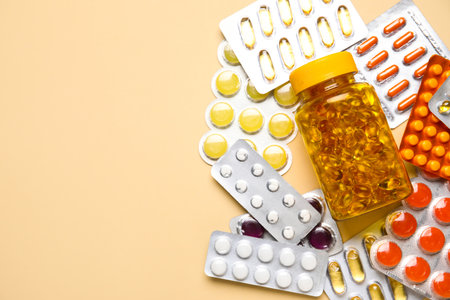 Different pills and bottles of medicines on yellow backgroundの写真素材