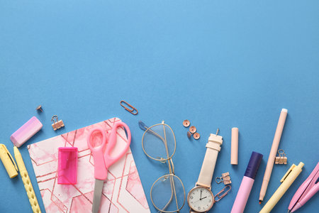 Different school stationery, notebook and glasses on blue backgroundの写真素材