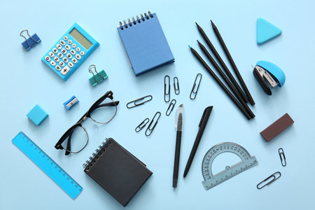 Different school stationery, notebooks and glasses on blue backgroundの写真素材