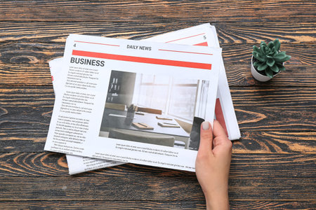 woman reading newspaper on wooden background