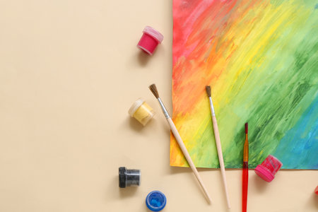 Brushes, paints and painting on beige backgroundの写真素材