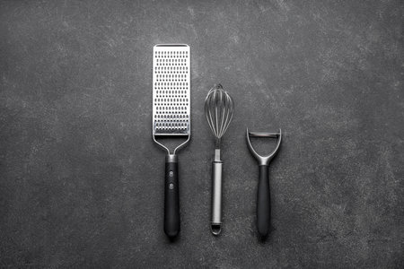 Grater, whiskey and vegetable peeler on dark backgroundの写真素材