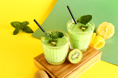 Glasses of fresh kiwi smoothie with mint and lemon on colorful backgroundの写真素材