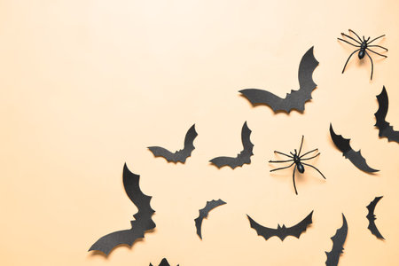 Paper bats and spiders for Halloween party on yellow background