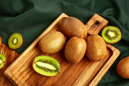 Board with fresh kiwi on wooden backgroundの写真素材