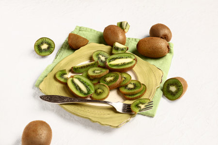 Plate with slices of fresh kiwi on white backgroundの写真素材