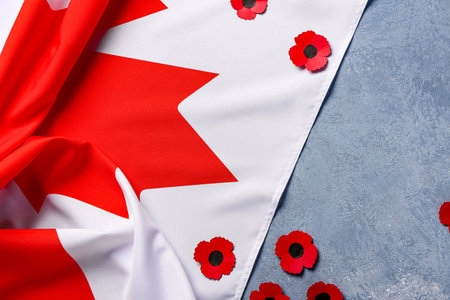 Poppy flowers with flag of Canada on grunge blue background. Remembrance Dayの写真素材