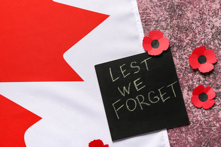 Poppy flowers with flag of Canada and card on grunge pink background. Remembrance Dayの写真素材
