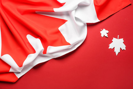 Flag of Canada and paper maple leaves on red backgroundの写真素材