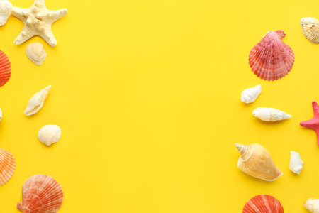Frame made of different seashells and starfish on yellow background