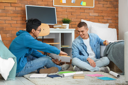 Male students doing homework in dorm room