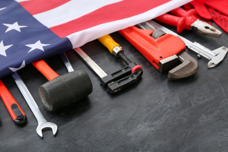 Different tools under USA flag on black grunge background. labor day celebration