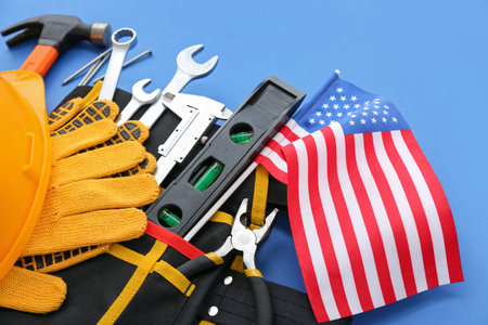 Belt with different tools and USA flag on blue background. labor day celebrationの写真素材