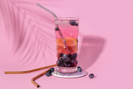Glass of fresh blueberry lemonade on pink backgroundの写真素材