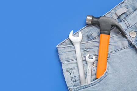 Tools in jeans pocket on blue background. labor day celebrationの写真素材