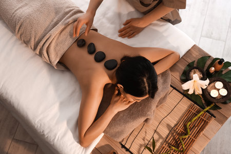 Pretty young Asian woman having massage in spa salon, top viewの写真素材