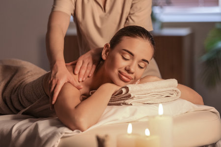 Pretty young woman having massage in spa salonの写真素材