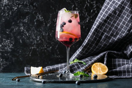 Board with glass of fresh blueberry lemonade and mint on dark tableの写真素材