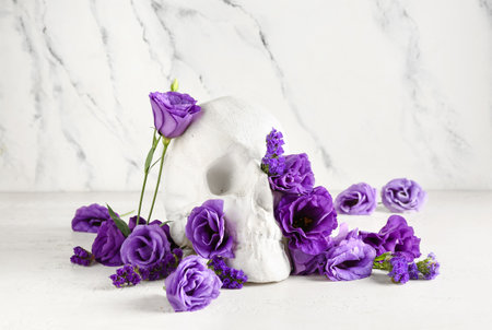 Human skull with beautiful eustoma flowers on white backgroundの写真素材