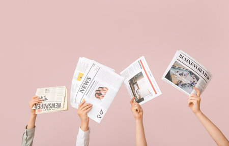 Female hands with different newspapers on color backgroundの写真素材