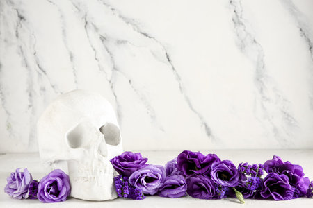 Human skull with beautiful eustoma flowers on white backgroundの写真素材