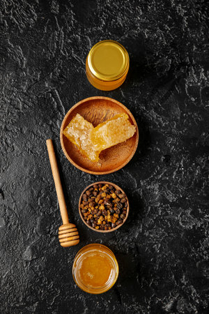 Composition with tasty honey, combs and beebread on dark backgroundの写真素材