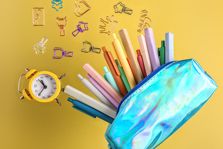Pencil case with different stationery and alarm clock flying against color backgroundの写真素材