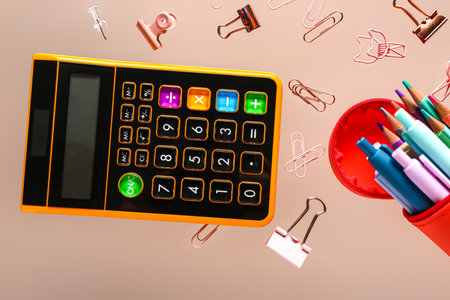 Pencil case with different stationery and calculator flying on color backgroundの写真素材