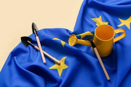 Flag of European Union with watering can and gardening tools on yellow backgroundの写真素材